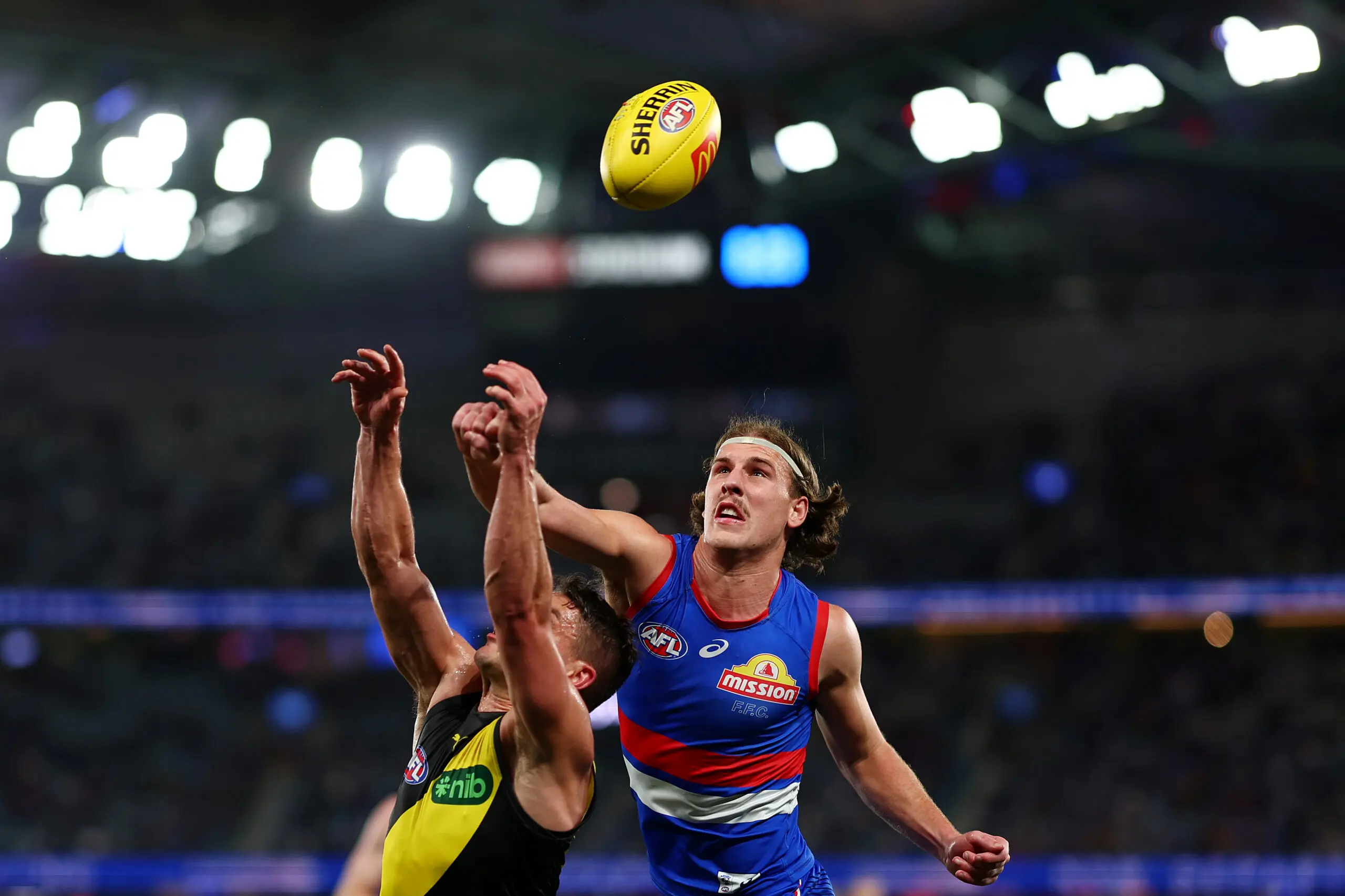 MELBOURNE, AUSTRALIA - JULY 25: Dion Prestia of the Tigers and Michael Sellwood of the Bulldogs compete for the ball during the round 20 AFL match between Western Bulldogs and Richmond Tigers at Marvel Stadium, on July 25, 2026, in Melbourne, Australia. (Photo by Morgan Hancock/Getty Images)