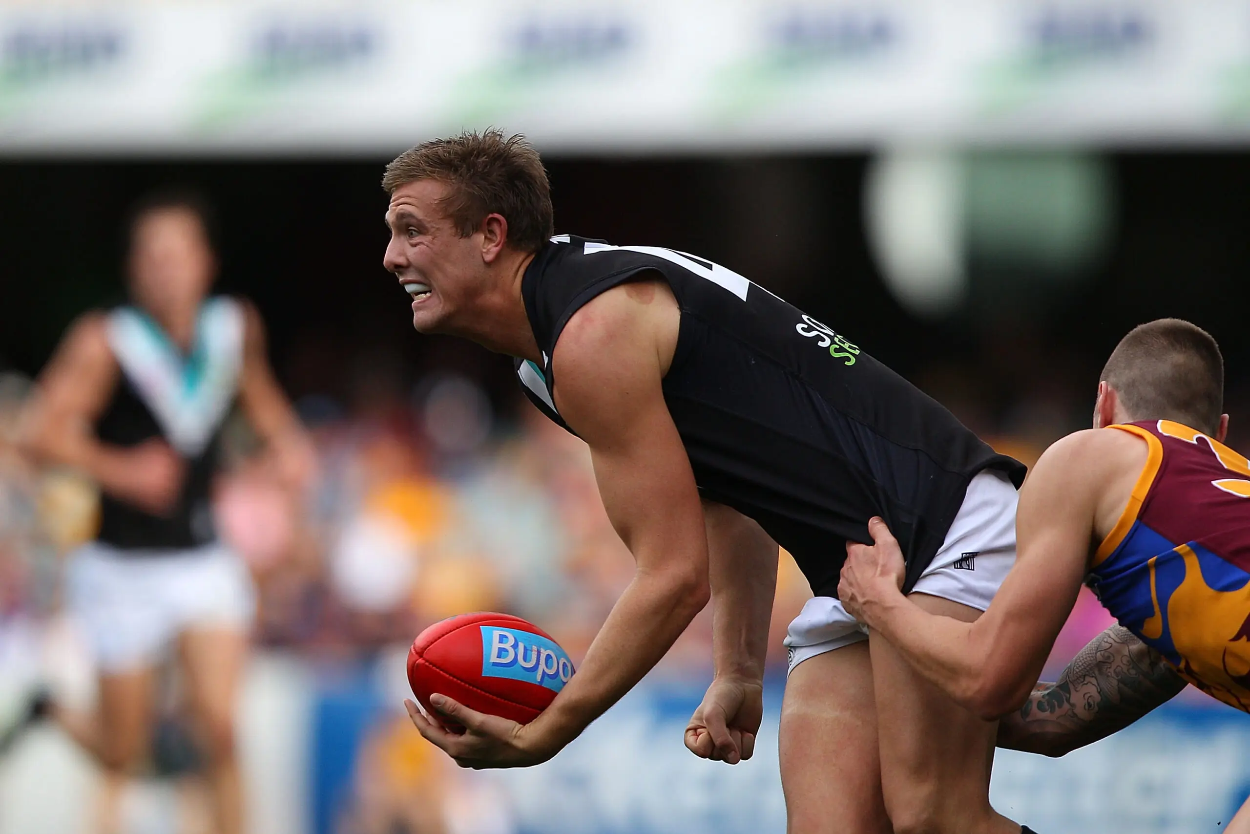 BRISBANE, AUSTRALIA - JULY 03: Daniel Stewart of the Power is tackled by Bryce Retzlaff of the Lions during the round 15 AFL match between the Brisbane Lions and Port Adelaide Power at The Gabba on July 3, 2011 in Brisbane, Australia. (Photo by Chris Hyde/Getty Images)