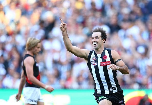 MELBOURNE, AUSTRALIA - APRIL 25: Steele Sidebottom of the Magpies celebrates after kicking a goal as Darcy Parish of the Bombers looks on during the 2016 AFL Round 05 ANZAC Day match between the Collingwood Magpies and the Essendon Bombers at the Melbourne Cricket Ground, Melbourne on April 25, 2016. (Photo by Scott Barbour/AFL Media)