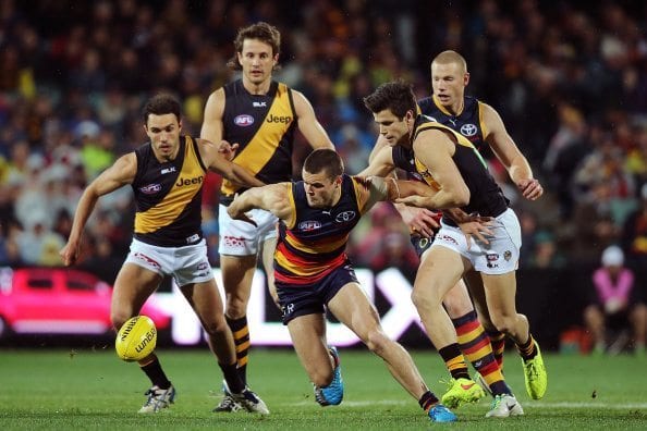 ADELAIDE, AUSTRALIA - AUGUST 16: Brad Crouch of the Crows and Trent Cotchin of the Tigers competes for the ball during the round 21 AFL match between the Adelaide Crows and the Richmond Tigers at Adelaide Oval on August 16, 2014 in Adelaide, Australia. (Photo by Morne de Klerk/Getty Images)