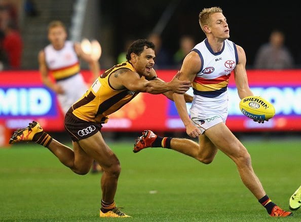 MELBOURNE, AUSTRALIA - APRIL 22: David Mackay of the Crows handballs whilst being tackled by Cyril Rioli of the Hawks during the round five AFL match between the Hawthorn Hawks and the Adelaide Crows at Melbourne Cricket Ground on April 22, 2016 in Melbourne, Australia. (Photo by Quinn Rooney/Getty Images)
