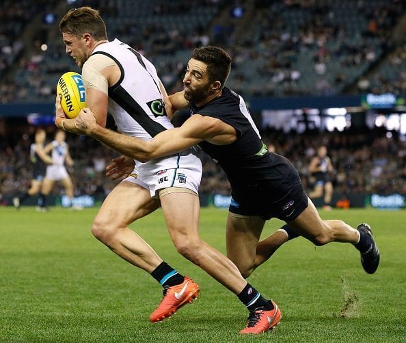 MELBOURNE, AUSTRALIA - MAY 15: Travis Boak of the Power is tackled by Kade Simpson of the Blues in his 250th game during the 2016 AFL Round 08 match between the Carlton Blues and Port Adelaide Power at Etihad Stadium, Melbourne on May 15, 2016. (Photo by Adam Trafford/AFL Media/Getty Images)