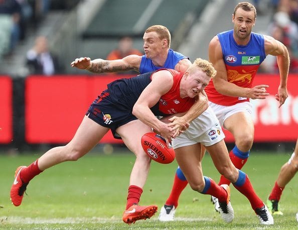 MELBOURNE, AUSTRALIA - MAY 22: Clayton Oliver of the Demons is tackled by Mitch Robinson of the Lions during the round nine AFL match between the Melbourne Demons and the Brisbane Lions at Melbourne Cricket Ground on May 22, 2016 in Melbourne, Australia. (Photo by Quinn Rooney/Getty Images)