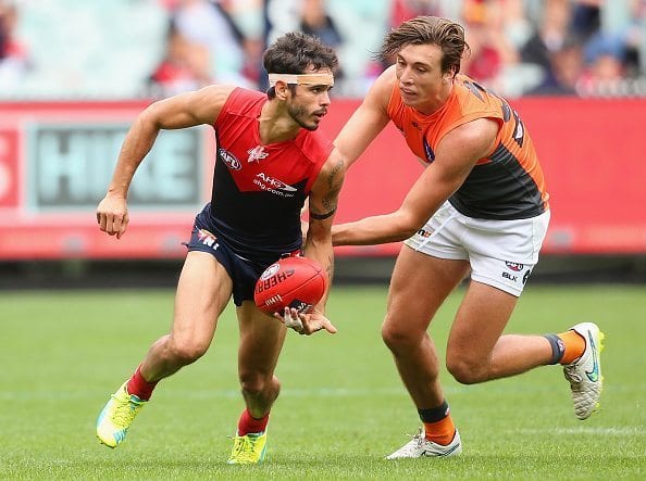 MELBOURNE, AUSTRALIA - MARCH 26: Jeff Garlett of the Demons handballs whilst being tackled by Caleb Marchbank of the Giants during the round one AFL match between the Melbourne Demons and the Greater Western Sydney Giants at Melbourne Cricket Ground on March 26, 2016 in Melbourne, Australia. (Photo by Quinn Rooney/Getty Images)