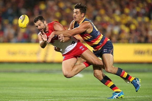 ADELAIDE, AUSTRALIA - APRIL 16: Heath Grundy of the Swans is tackled by Taylor Walker of the Crows during the 2016 AFL Round 04 match between the Adelaide Crows and the Sydney Swans at the Adelaide Oval on April 16, 2016 in Adelaide, Australia. (Photo by James Elsby/AFL Media/Getty Images)