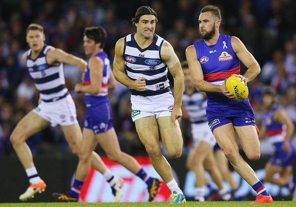 MELBOURNE, AUSTRALIA - JUNE 18: Matt Suckling of the Bulldogs runs with the ball away from Shane Kersten of the Cats during the round 13 AFL match between the Western Bulldogs and the Geelong Cats at Etihad Stadium on June 18, 2016 in Melbourne, Australia. (Photo by Michael Dodge/Getty Images)