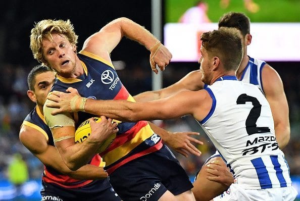 ADELAIDE, AUSTRALIA - JUNE 23: Rory Sloane of the Crows attempts to handball during the round 14 AFL match between the Adelaide Crows and the North Melbourne Kangaroos at Adelaide Oval on June 23, 2016 in Adelaide, Australia. (Photo by Daniel Kalisz/Getty Images)