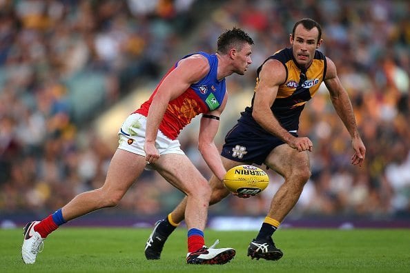 PERTH, WESTERN AUSTRALIA - MARCH 27: Pearce Hanley of the Lions looks to handball against Shannon Hurn of the Eagles during the AFL round one match between the West Coast Eagles and the Brisbane Lions at Domain Stadium on March 27, 2016 in Perth, Australia. (Photo by Paul Kane/Getty Images)