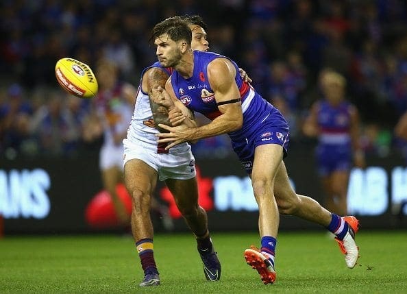 MELBOURNE, AUSTRALIA - APRIL 23: Koby Stevens of the Bulldogs handballs whilst being tackled by Allen Christensen of the Lions during the round five AFL match between the Western Bulldogs and the Brisbane Lions at Etihad Stadium on April 23, 2016 in Melbourne, Australia. (Photo by Quinn Rooney/Getty Images)