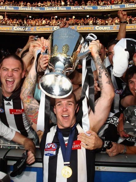 MELBOURNE, AUSTRALIA - OCTOBER 02:  Dane Swan of the Magpies celebrates withfans whilst holding up the premiership cup after the Magpies won the AFL Grand Final Replay match between the Collingwood Magpies and the St Kilda Saints at Melbourne Cricket Ground on October 2, 2010 in Melbourne, Australia.  (Photo by Quinn Rooney/Getty Images)