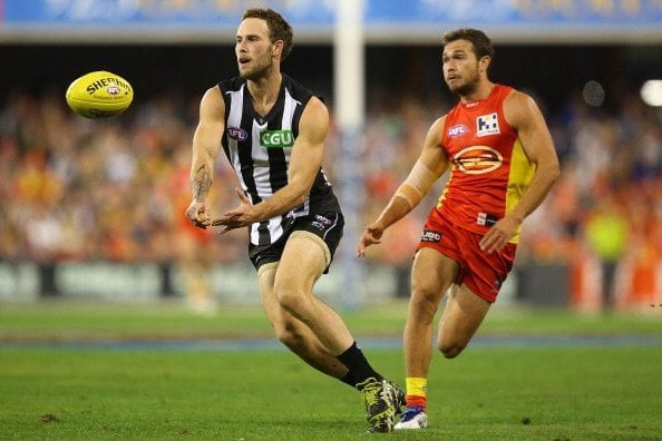 GOLD COAST, AUSTRALIA - JULY 05:  Brent Macaffer of the Magpies handballs during the round 16 AFL match between the Gold Coast Suns and the Collingwood Magpies at Metricon Stadium on July 5, 2014 in Gold Coast, Australia.  (Photo by Chris Hyde/Getty Images)