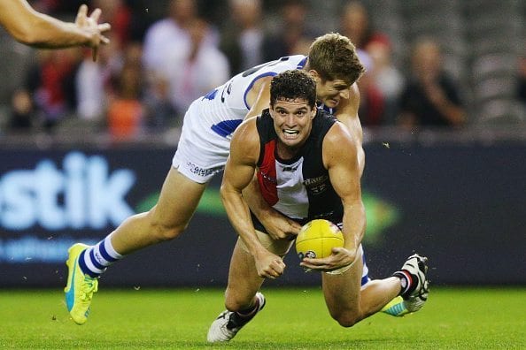 MELBOURNE, AUSTRALIA - MAY 08:  Leigh Montagna of the Saints handballs away from a tackling Nick Dal Santo of the Kangaroos during the round seven AFL match between the St Kilda Saints and the North Melbourne Kangaroos at Etihad Stadium on May 8, 2016 in Melbourne, Australia.  (Photo by Michael Dodge/Getty Images)