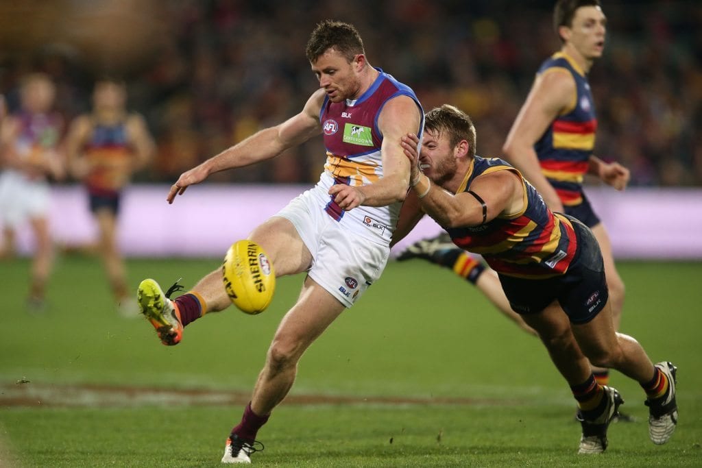 ADELAIDE, AUSTRALIA - AUGUST 06: Pearce Hanley of the Lions is tackled by Daniel Talia of the Crows during the 2016 AFL Round 20 match between the Adelaide Crows and the Brisbane Lions at Adelaide Oval on August 06, 2016 in Adelaide, Australia. (Photo by James Elsby/AFL Media/Getty Images)