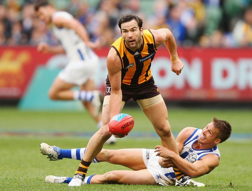 MELBOURNE, AUSTRALIA - AUGUST 13: Jordan Lewis of the Hawks handballs away from Andrew Swallow of the Kangaroos during the round 21 AFL match between the Hawthorn Hawks and the North Melbourne Kangaroos at Melbourne Cricket Ground on August 13, 2016 in Melbourne, Australia. (Photo by Michael Dodge/Getty Images)