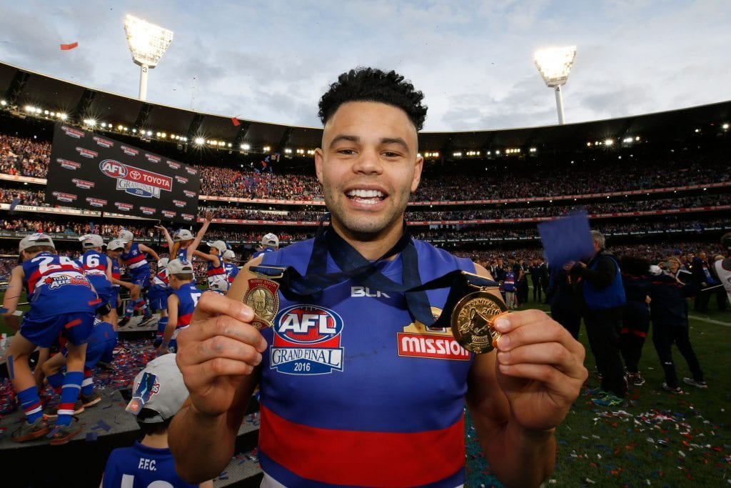 MELBOURNE, VICTORIA - OCTOBER 01: Jason Johannisen of the Bulldogs holds his Norm Smith and Premiership medals after the 2016 AFL Grand Final match between the Sydney Swans and the Western Bulldogs at Melbourne Cricket Ground on October 1, 2016 in Melbourne, Australia. (Photo by Darrian Traynor/AFL Media/Getty Images)