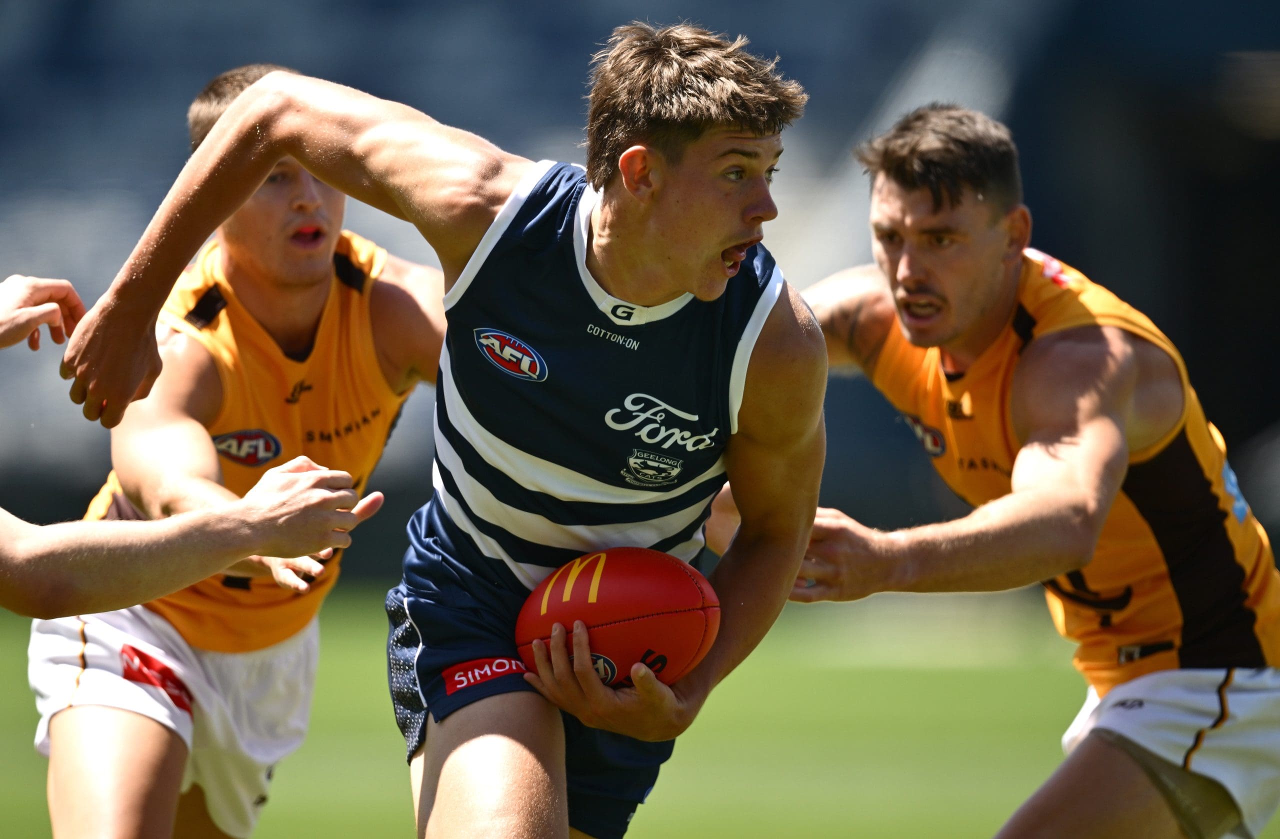 GEELONG, AUSTRALIA - FEBRUARY 17: Connor O'Sullivan of the Cats handballs whilst being tackled during the AFL practice match between Geelong Cats and Hawthorn Hawks at GMHBA Stadium on February 17, 2025 in Geelong, Australia. (Photo by Quinn Rooney/Getty Images)