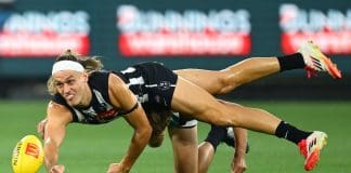 MELBOURNE, AUSTRALIA - MARCH 15: Darcy Moore of the Magpies handballs whilst being tackled during the round one AFL match between Collingwood Magpies and Port Adelaide Power at Melbourne Cricket Ground, on March 15, 2025, in Melbourne, Australia. (Photo by Quinn Rooney/Getty Images)