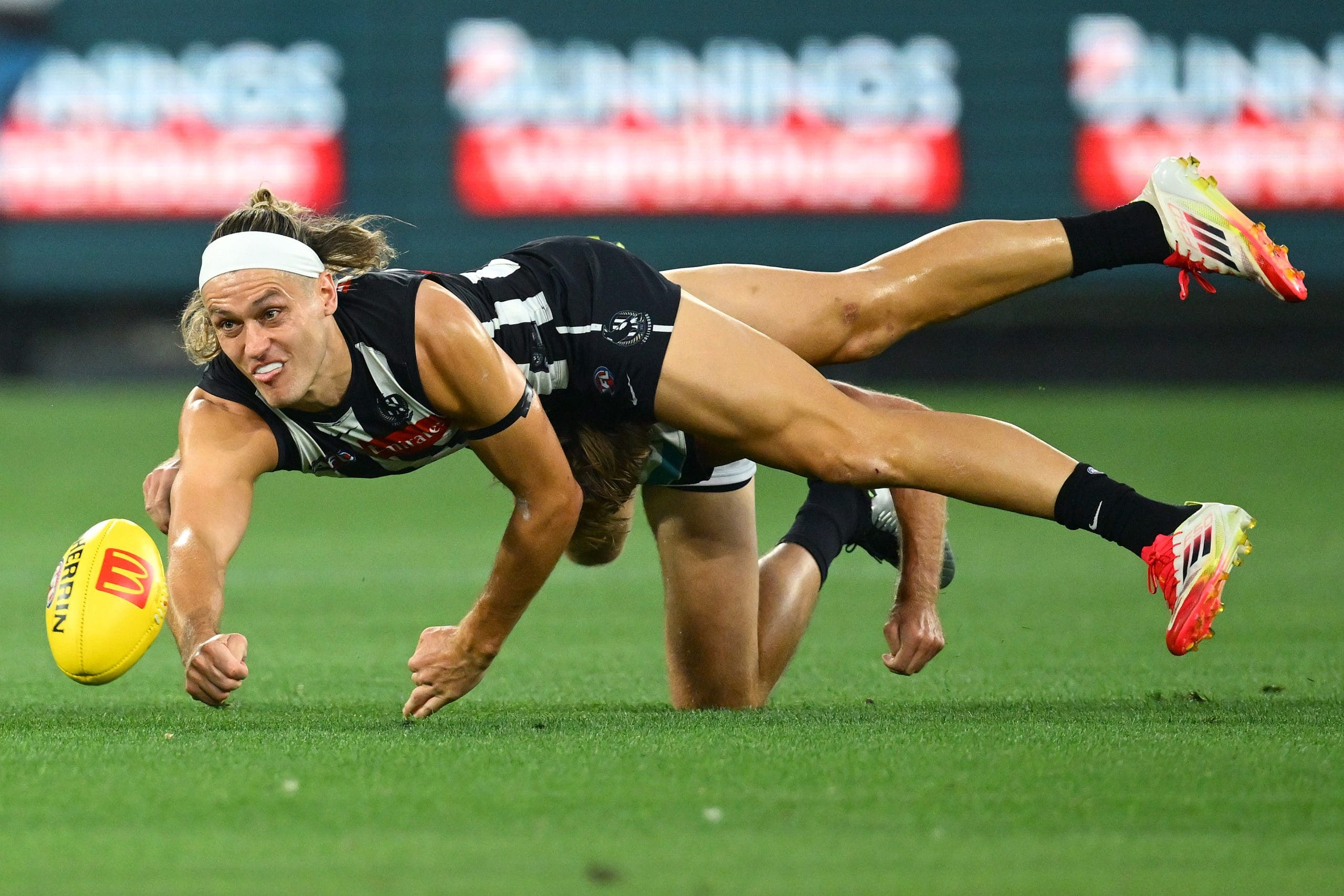 MELBOURNE, AUSTRALIA - MARCH 15: Darcy Moore of the Magpies handballs whilst being tackled during the round one AFL match between Collingwood Magpies and Port Adelaide Power at Melbourne Cricket Ground, on March 15, 2025, in Melbourne, Australia. (Photo by Quinn Rooney/Getty Images)