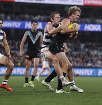 GEELONG, AUSTRALIA - MAY 10: Tom Atkins of the Cats tackles Jason Horne-Francis of the Power during the round nine AFL match between Geelong Cats and Port Adelaide Power at GMHBA Stadium, on May 10, 2024, in Geelong, Australia. (Photo by Darrian Traynor/Getty Images)