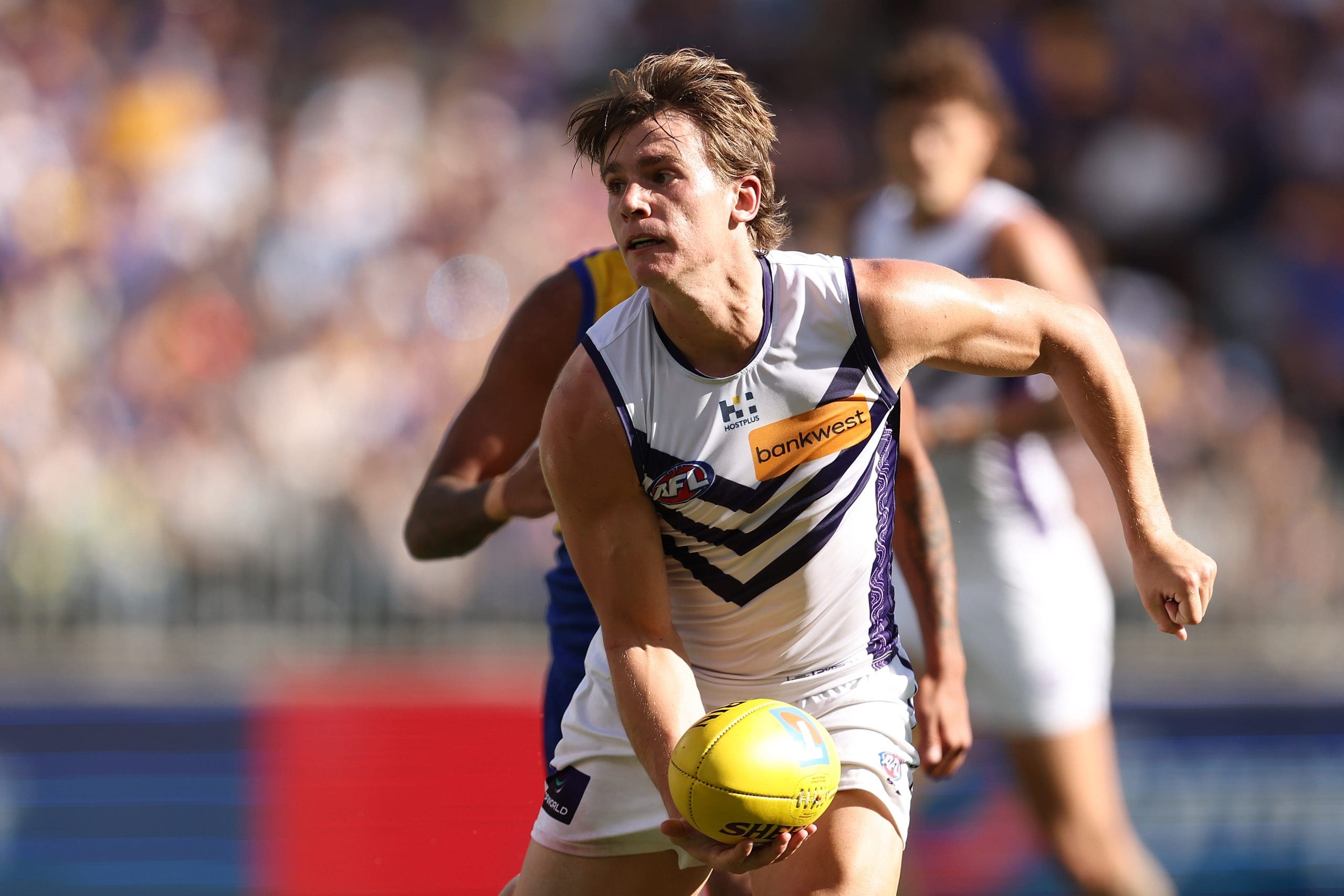 PERTH, AUSTRALIA - MARCH 30: Caleb Serong of the Dockers looks to handball during the round three AFL match between West Coast Eagles and Fremantle Dockers at Optus Stadium, on March 30, 2025, in Perth, Australia. (Photo by Paul Kane/Getty Images)
