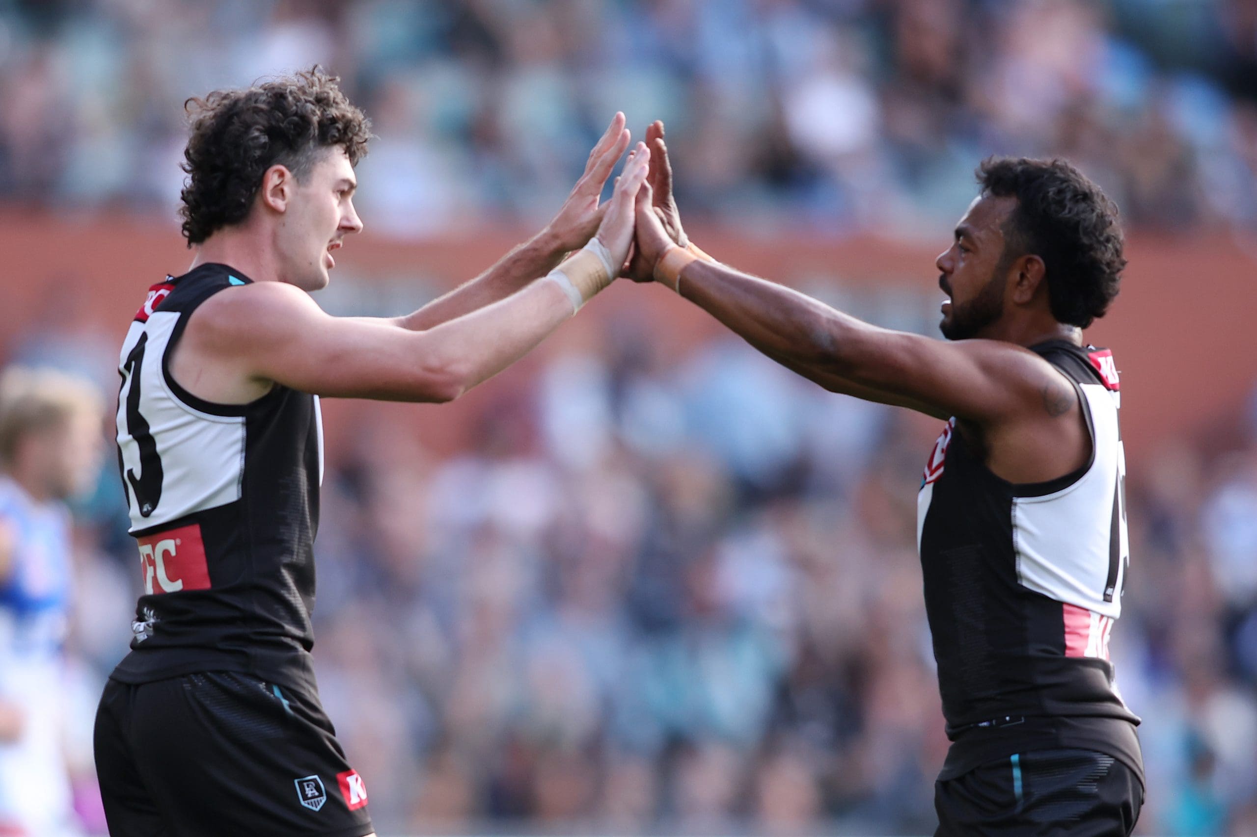 ADELAIDE, AUSTRALIA - APRIL 26: Darcy Byrne-Jones of the Power celebrates a goal with teammate Willie Rioli during the round seven AFL match between Port Adelaide Power and North Melbourne Kangaroos at Adelaide Oval, on April 26, 2025, in Adelaide, Australia. (Photo by Maya Thompson/Getty Images)