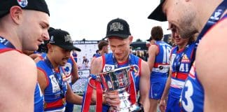 MELBOURNE, AUSTRALIA - SEPTEMBER 21: Adam Treloar of the Bulldogs holds the trophy and celebrates with teammates after winning the 2025 VFL Grand Final match between Footscray Bulldogs and Southport Sharks at Ikon Park on September 21, 2025 in Melbourne, Australia. (Photo by Daniel Pockett/Getty Images)