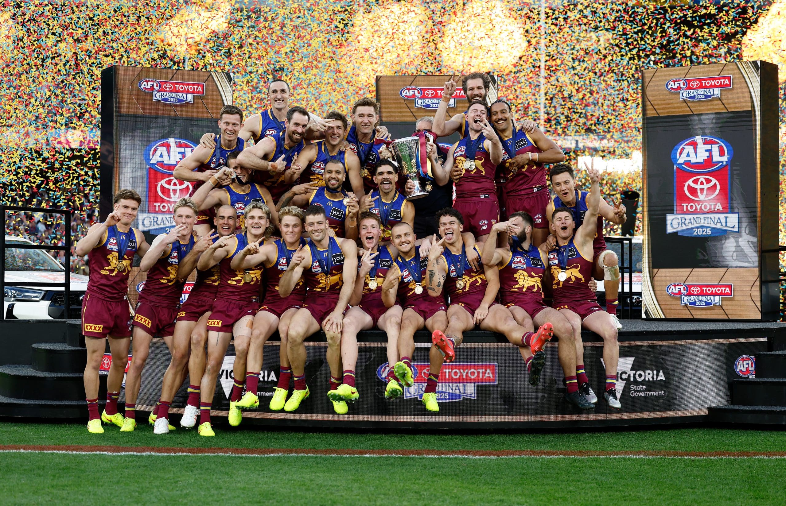 MELBOURNE, AUSTRALIA - SEPTEMBER 27: The Lions celebrate on the dais after winning the AFL Grand Final match between the Geelong Cats and the Brisbane Lions at the Melbourne Cricket Ground on September 27, 2025 in Melbourne, Australia. (Photo by Michael Willson/AFL Photos via Getty Images)