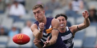 GEELONG, AUSTRALIA - MARCH 15: Liam Reidy of the Dockers handballs under pressure from Jack Henry of the Cats during the round one AFL match between Geelong Cats and Fremantle Dockers at GMHBA Stadium, on March 15, 2025, in Geelong, Australia. (Photo by Daniel Pockett/Getty Images)